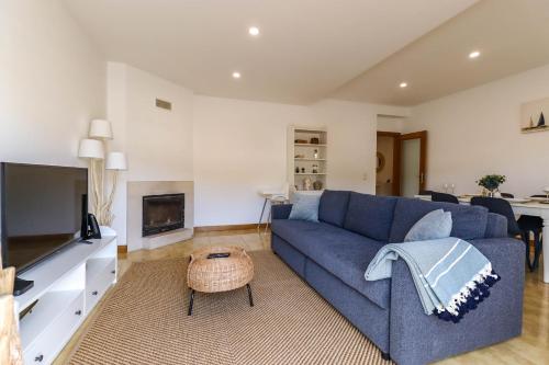 a living room with a blue couch and a tv at Flor do Mar - Spacious Apartment with Balcony in Vila Praia de Âncora