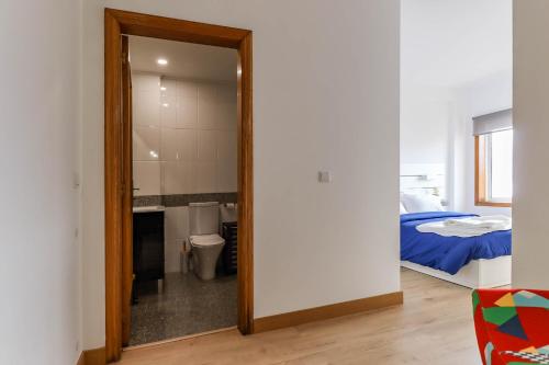 a mirror in a bedroom with a bed and a bathroom at Flor do Mar - Spacious Apartment with Balcony in Vila Praia de Âncora