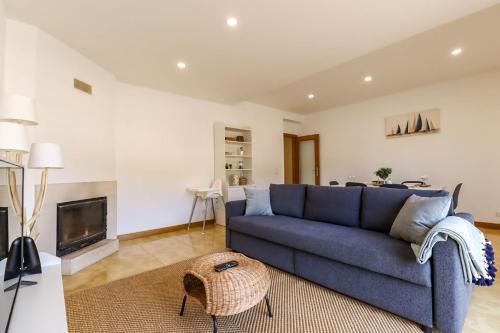a living room with a blue couch and a fireplace at Flor do Mar - Spacious Apartment with Balcony in Vila Praia de Âncora