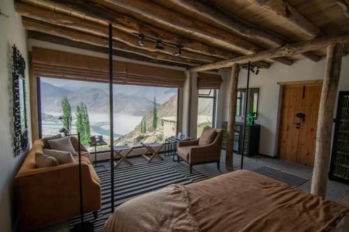 a bedroom with a bed and a large window at BROQ in Skardu