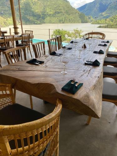 a long wooden table with wine glasses and chairs at Summer C in Macanal
