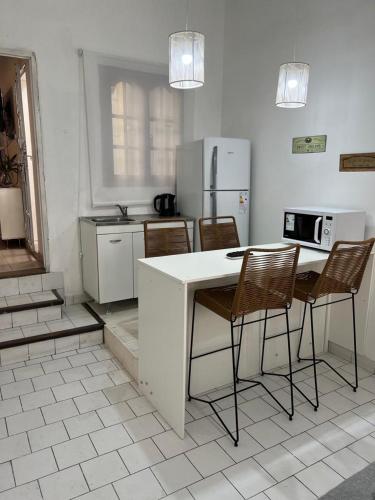 een keuken met een tafel en stoelen en een koelkast bij Agradable departamento en centro de Salta in Salta