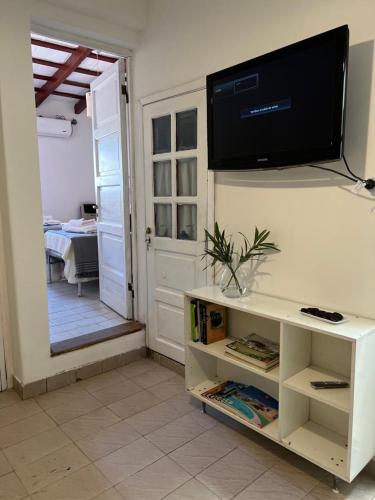 een woonkamer met een tv aan een muur met een tafel bij Agradable departamento en centro de Salta in Salta