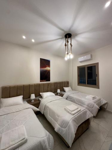 a bedroom with three beds and a ceiling at Jasmine flower hostel in Madaba