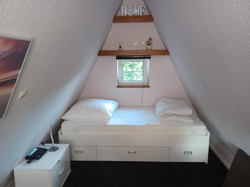 Habitación pequeña con cama y ventana en Ferienhaus Elbliebe - kleine Hunde bis 25 cm willkommen en Dannenberg