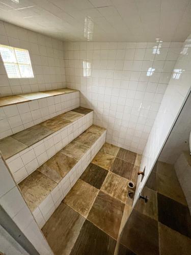 an empty bathroom with two shelves and a shower at Chale das hortensias in Petrópolis