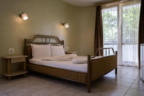 a bedroom with a bed with white sheets and a window at Jeweller Hotel in Ruse