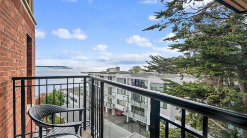 a balcony with a chair and a view of the water at Oak Bay Beach Hotel in Victoria