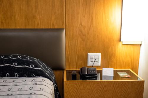 a hotel room with a bed and a telephone at DELPLAZA Excelsior São Paulo - By Monreale in Sao Paulo