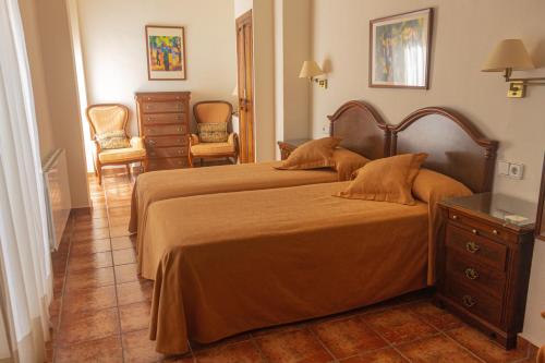 a bedroom with two beds and a dresser at Hotel Tàrbena in Tárbena
