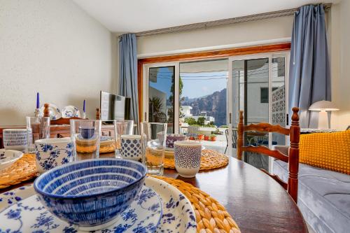a dining room table with blue and white dishes on it at One-bedroom with views of Los Gigantes in Santiago del Teide