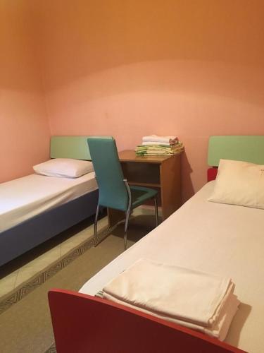 Cette chambre comprend deux lits, un bureau et une chaise. dans l'établissement Private Residence Full Apartment in Golem, à Golem