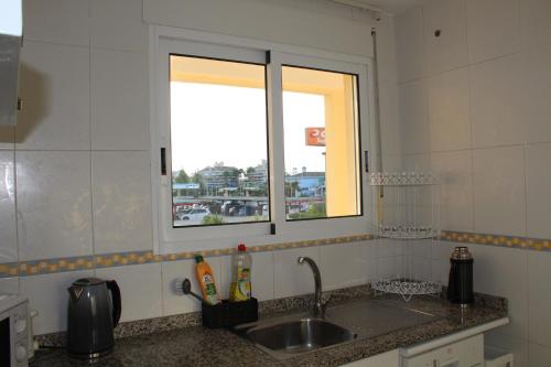 un comptoir de cuisine avec un évier et une fenêtre dans l'établissement Denia Holiday Service, à Dénia
