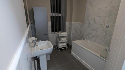 ein Badezimmer mit einem Waschbecken, einer Badewanne, einem WC und einem Spiegel in der Unterkunft 2 Bed Property Close to Centre Trenth Stay in Belle Isle