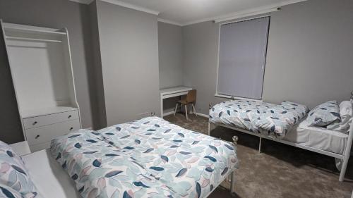 Belle Isle的住宿－2 Bed Property Close to Centre Trenth Stay，一间卧室配有两张床和一张书桌