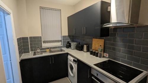 a small kitchen with a sink and a dishwasher at 2 Bed Property Close to Centre Trenth Stay in Belle Isle