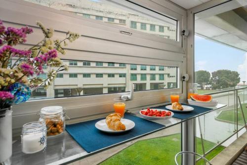 a breakfast table with croissants and fruit on a balcony at Ocean Front 2bed Luxury w/ Elevator Parking WI-FI in Matosinhos