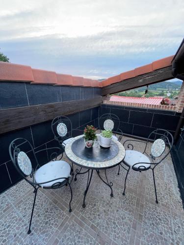 a patio table and chairs on a balcony at La Casa de Fefita (Stone house in a privileged environment 35 km from Bilbao) in Villanueva de Mena