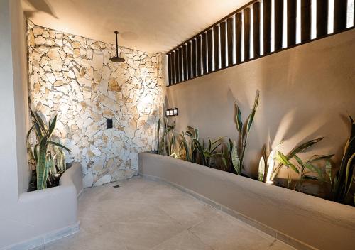 a hallway with plants and a stone wall at Casa Candela in San Jerónimo