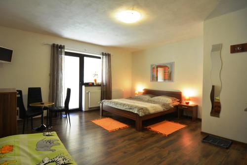 a bedroom with a bed and a table and chairs at Villa Gold in Nová Lesná