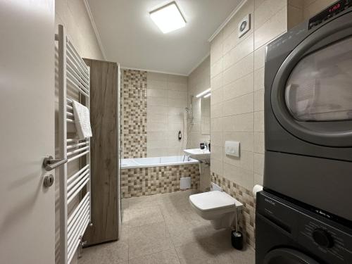 a bathroom with a toilet and a washing machine at elisio - Bricks Apartment in Braşov