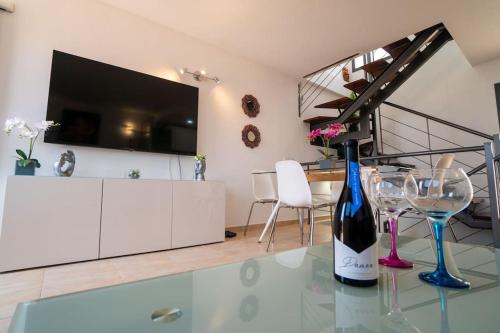 een woonkamer met een glazen tafel en een fles wijn bij Casa Alfred, El Cotillo, Best one beach to 150 m WIFI fiber in Cotillo