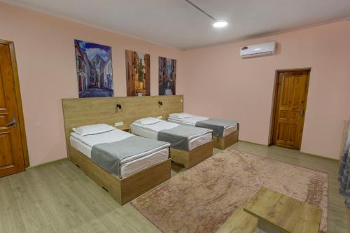 una camera con tre letti e un tappeto di Koisha a Bishkek
