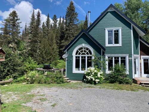 Casa verde con ventana blanca en Le Ti Moose - Les Chalets Spa Canada en La Malbaie