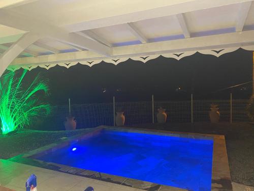 a swimming pool lit up at night with green lights at Les Appart villa Sunbay Caraibes avec piscine privative vue mer et montagne in Le François