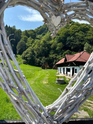 a house in a field with a heart shaped window at Cabanutze Satic in Rucăr