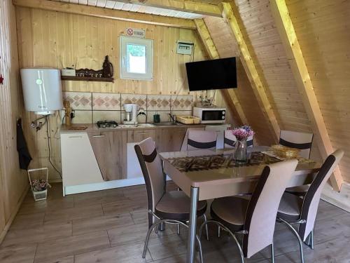a kitchen and dining room with a table and chairs at Cabanutze Satic in Rucăr