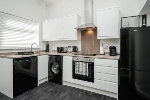 uma cozinha com um frigorífico preto e uma máquina de lavar louça em Dacy Lodge - Anfield Apartments em Liverpool