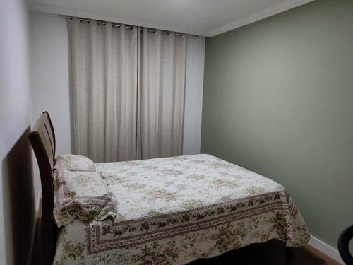 a bedroom with a bed with a blanket on it at Apartamento em Teresópolis - RJ in Teresópolis