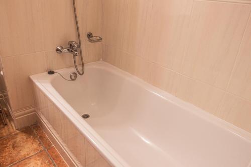 a white bath tub with a shower in a bathroom at Hotel Tàrbena in Tárbena