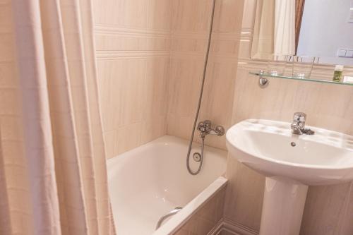 a bathroom with a tub and a sink and a shower at Hotel Tàrbena in Tárbena