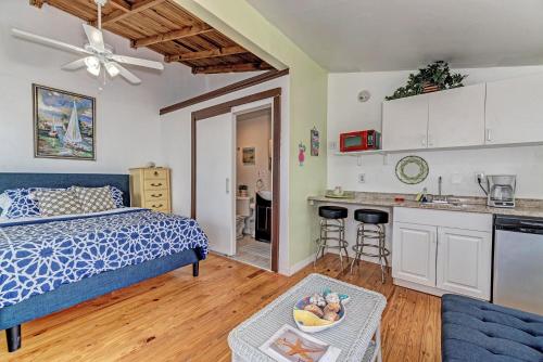 a bedroom with a bed and a kitchen with a table at Playa Esmeralda Studios in Bradenton Beach