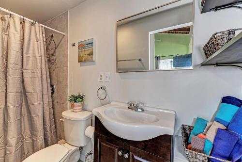 een badkamer met een wastafel, een toilet en een spiegel bij Playa Esmeralda Studios in Bradenton Beach