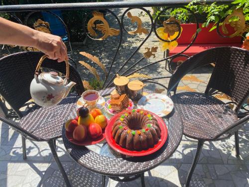 a table with a bowl of fruit and a plate of food at Eliz Garden in Kutaisi