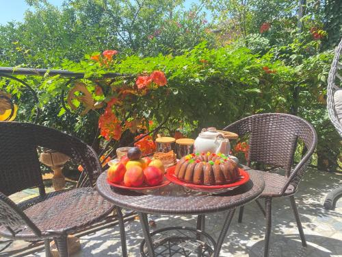 a table with a plate of fruit and a cake at Eliz Garden in Kutaisi