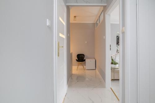 a hallway with a door leading into a room with a chair at Gold Glamour Apartment Sopot z dwoma sypialniami, duzy balkon in Sopot