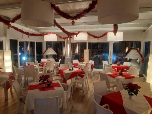 a dining room with red and white tables and chairs at Hotel Piccolo Mondo in Acquappesa