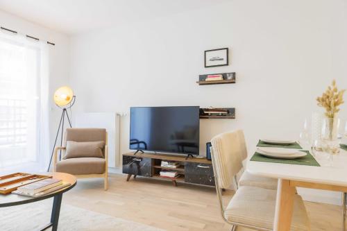 - un salon avec une table à manger et une télévision dans l'établissement Modern apartment - 2BR-5P - Puces de Saint-Ouen, à Saint-Ouen