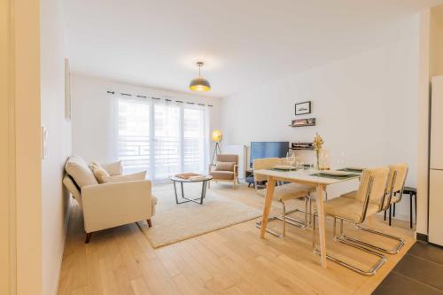 une salle à manger et un salon avec une table et des chaises dans l'établissement Modern apartment - 2BR-5P - Puces de Saint-Ouen, à Saint-Ouen