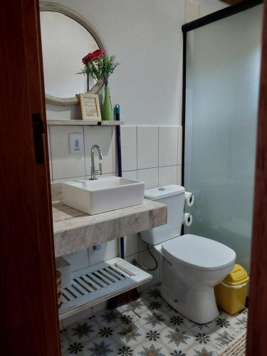 une salle de bains avec lavabo et toilettes dans l'établissement Chalé Canto Mundo, à Brazópolis
