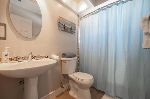 a bathroom with a toilet and a sink and a mirror at Half mile to the beach! Heated Pool & Spa, with Tiki on boat dock! - Villa Changes in Attitude in Cape Coral