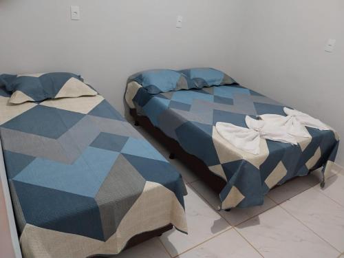 two beds sitting next to each other in a room at Pousada JF tour in Ponte Alta do Norte