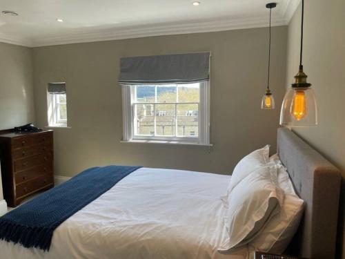 a bedroom with a white bed with a window at Crescent Penthouse with Stunning Views and free parking in Bath