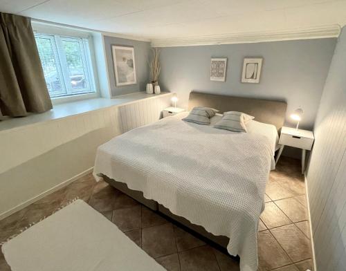 a bedroom with a white bed and a window at One bedroom basement apartment in the city in Tromsø