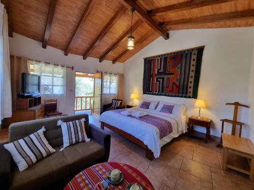 1 dormitorio con 1 cama grande y 1 sofá en Copacabaña Lodge, en Chancos