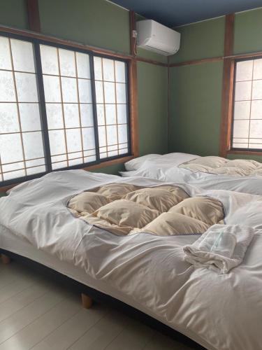 una camera con tre letti con cuscini sopra di guest house goose - Vacation STAY 21037v a Hirosaki